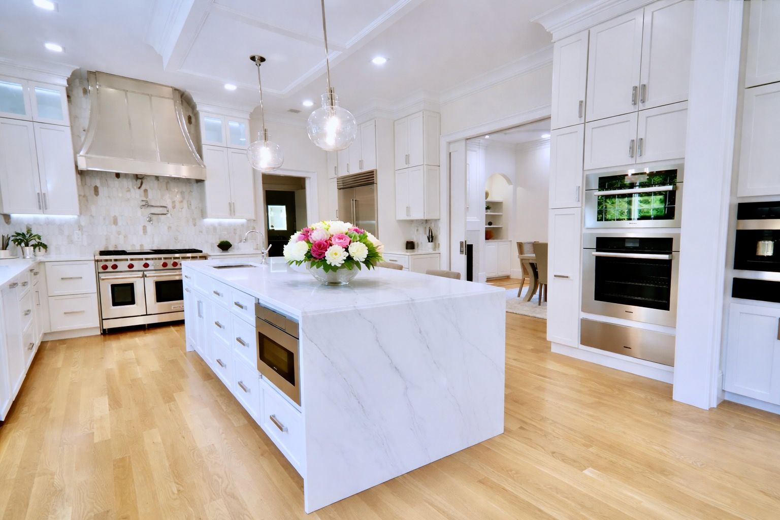 A large kitchen with white cabinets and a large island.