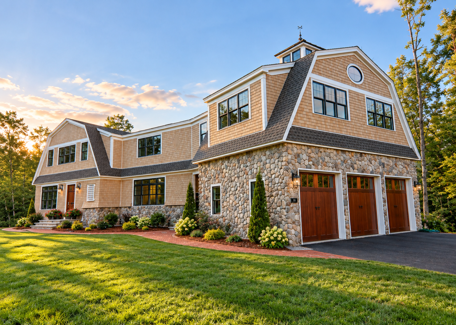 A large house with a stone wall in front of it.
