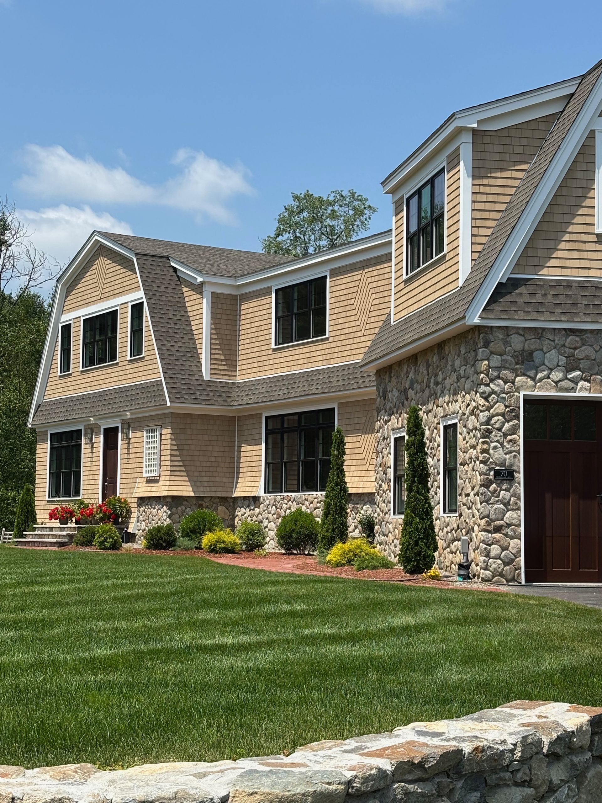 A large house with a stone wall in front of it