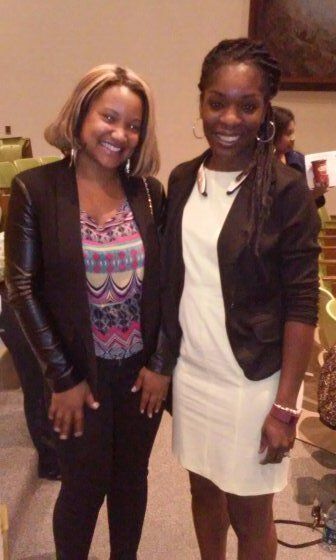 Two women are posing for a picture together and smiling for the camera.