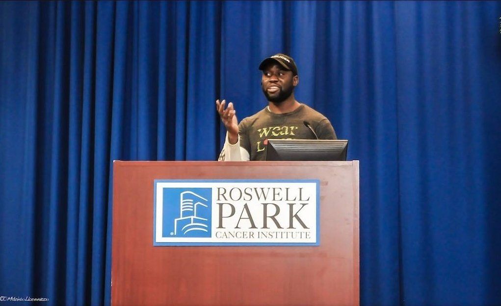 A man is giving a speech at a podium that says roswell park