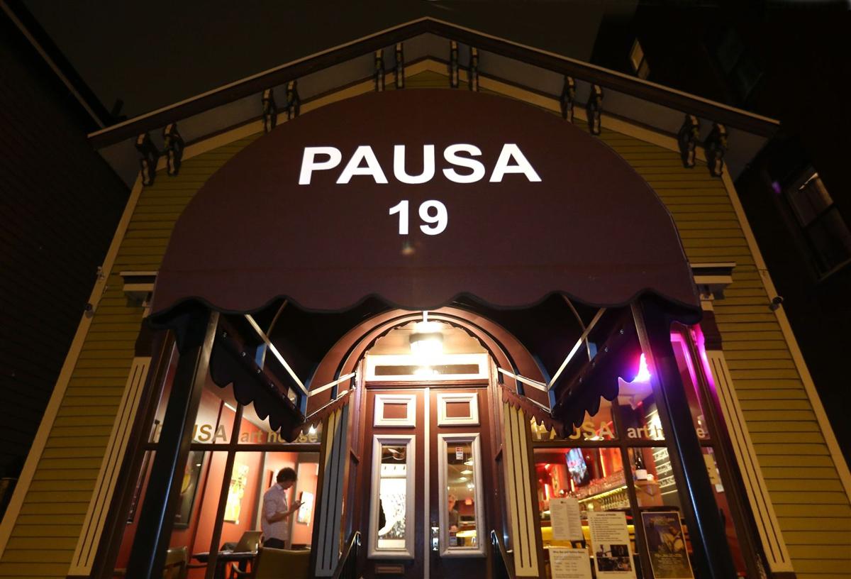 A building with a purple awning that says pausa 19