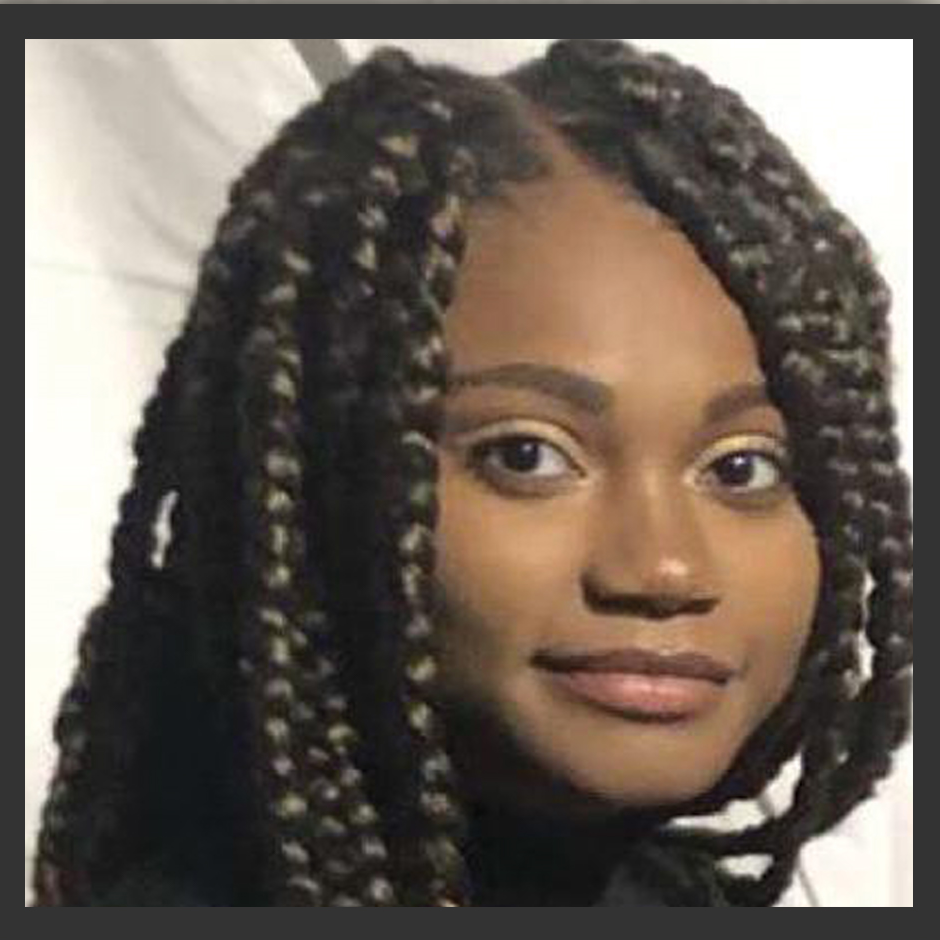 A close up of a woman 's face with braids.