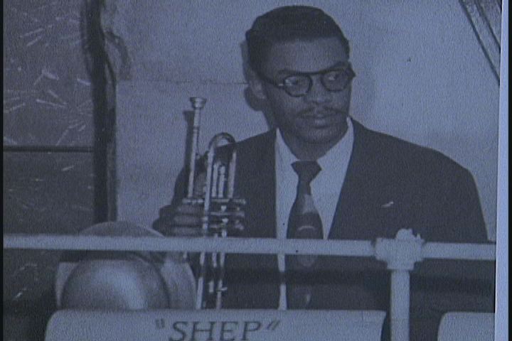 A black and white photo of a man playing a trumpet