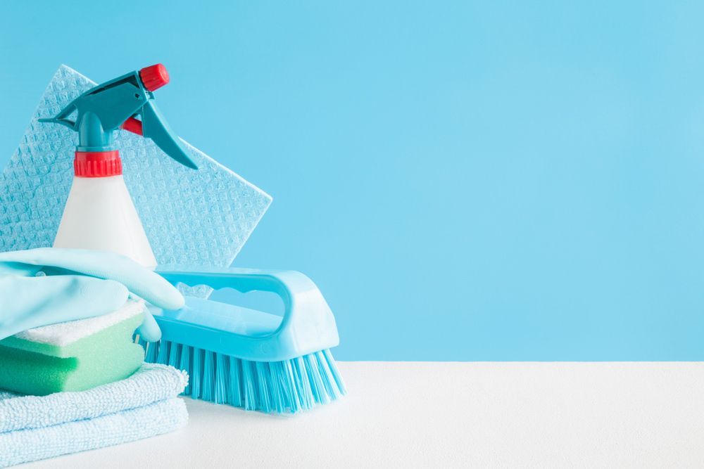 A Spray Bottle , Brush , Sponges , And Towels Are On A Table — DP Cleaning Supplies Pty Ltd In Mareeba, QLD