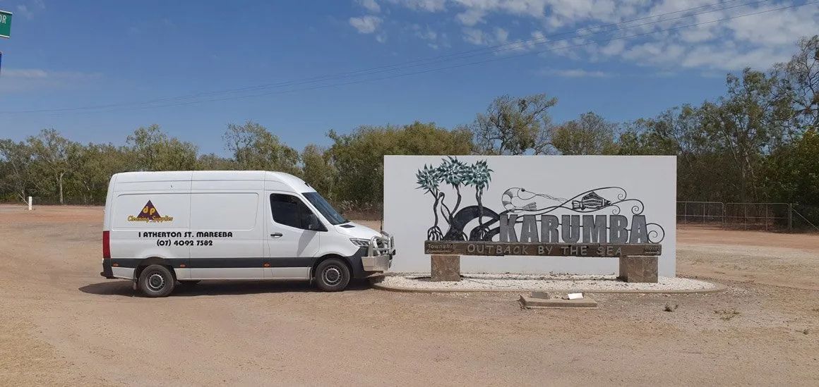A White Van Is Parked Next To A Sign That Says Karumba— DP Cleaning Supplies Pty Ltd In Mareeba, QLD