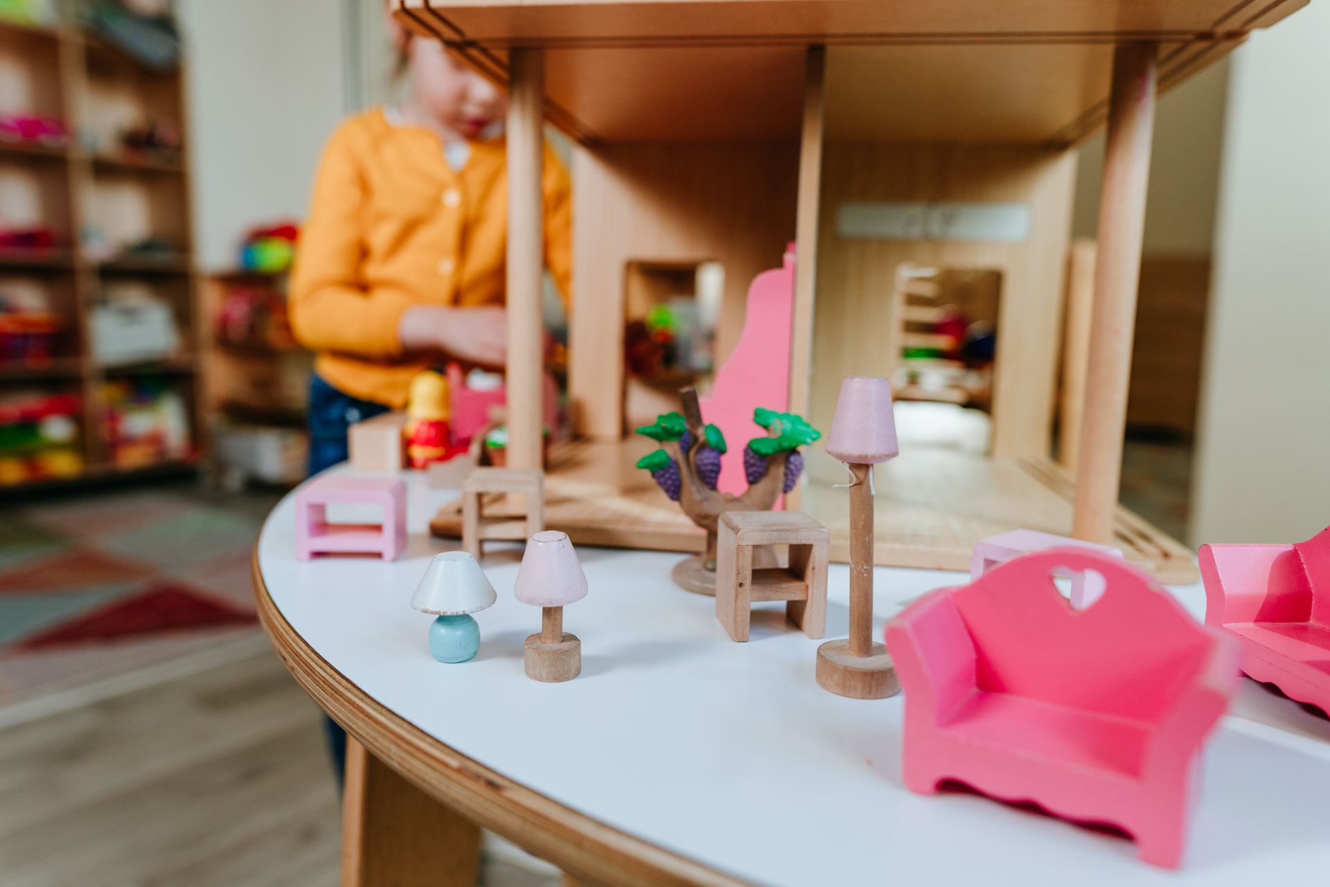 Child playing with dollhouse and miniature furniture. Child playing with dollhouse and miniature furniture.