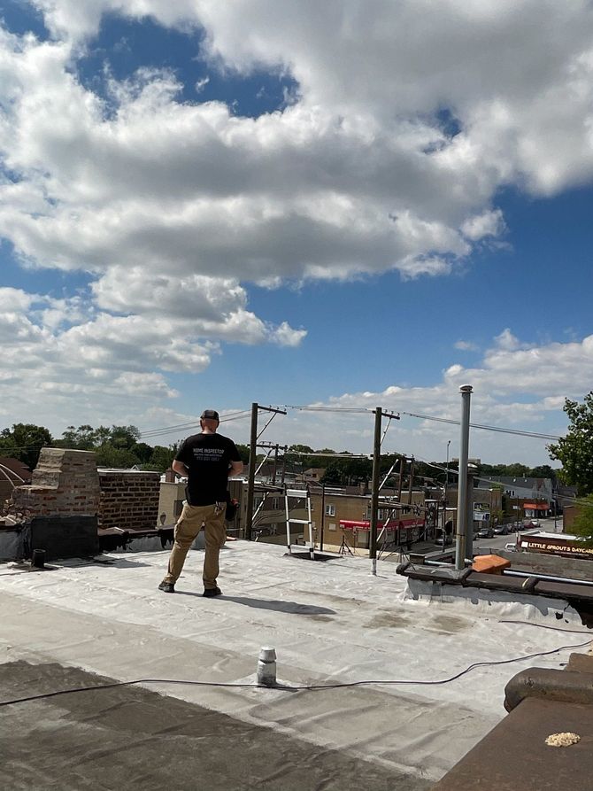 A man in a black shirt is standing on a roof.