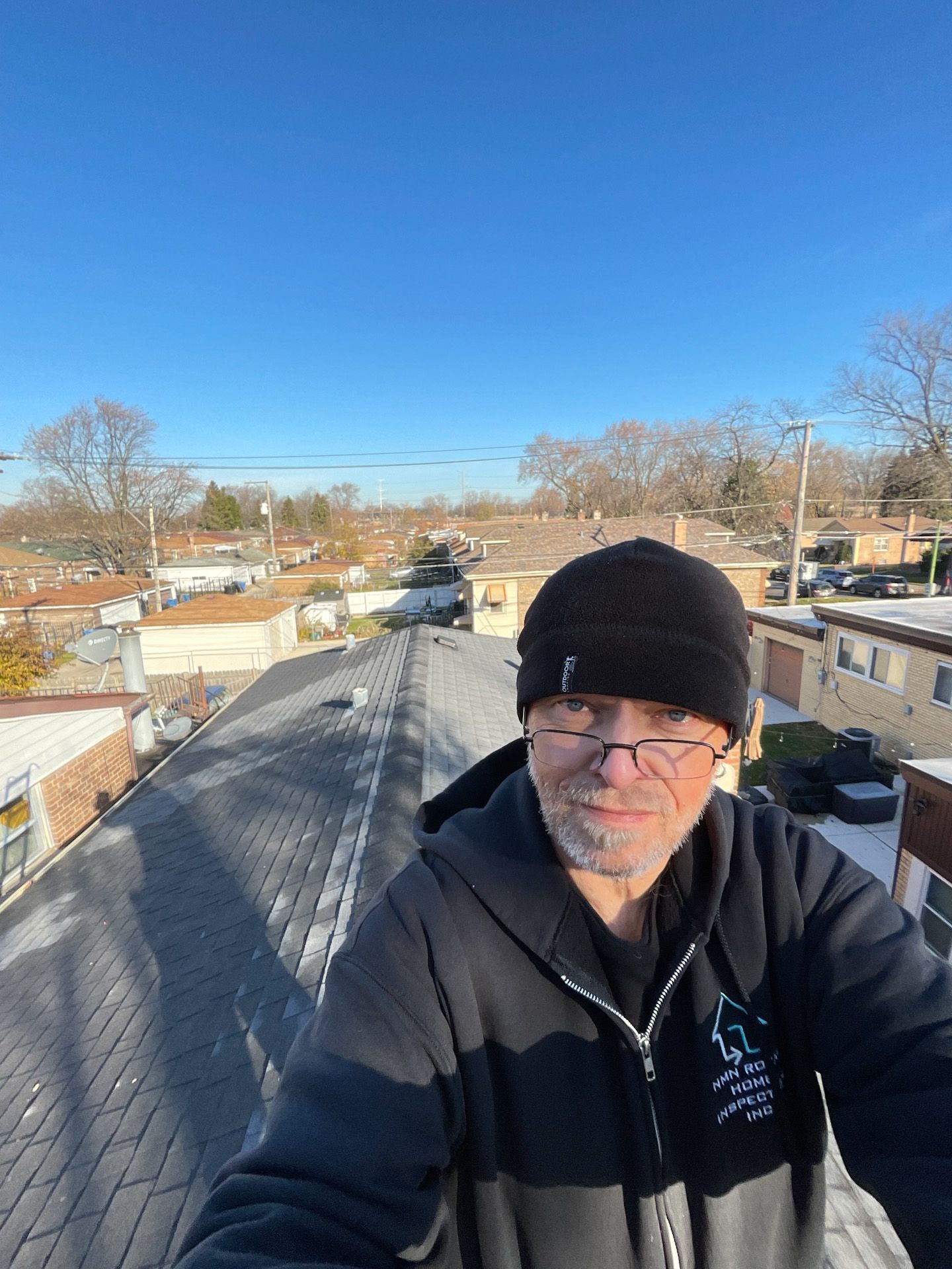 A man is taking a selfie on the roof of a house.
