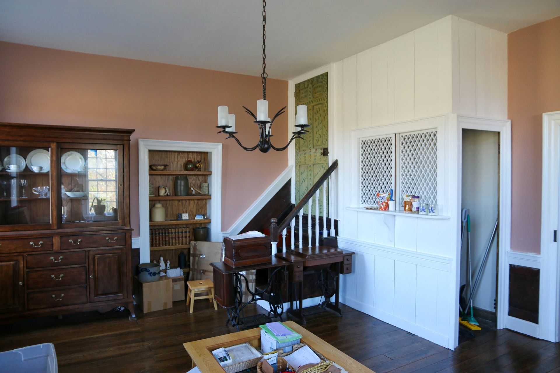 Dining room with dark wood china cabinet, staircase, and white lattice half-wall divider