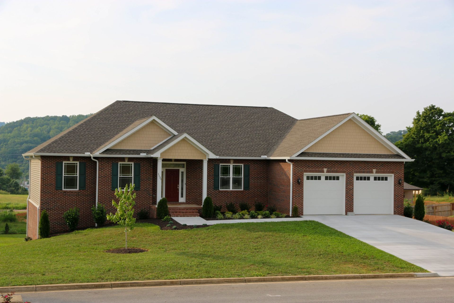 Single-story brick suburban house with two-car garage and a sloped driveway