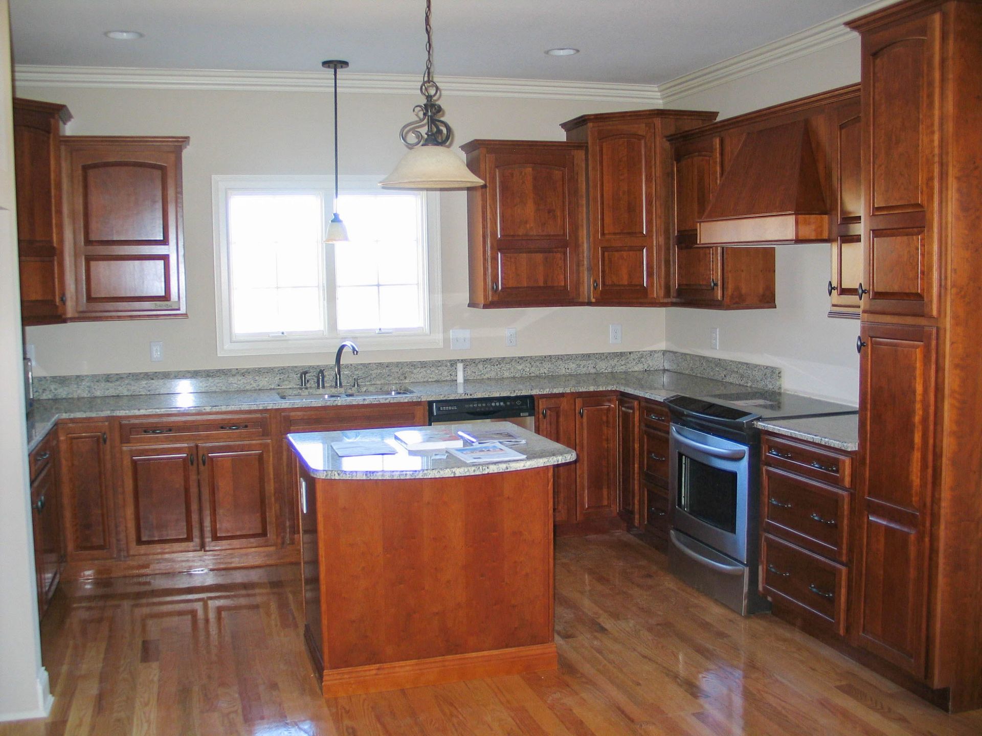 Wooden kitchen with island, granite countertops, and a window over the sink