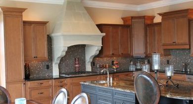Modern kitchen with wooden cabinets, granite island, and stone range hood
