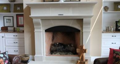 White living room fireplace with shelves, framed photos, and decorative items on either side.
