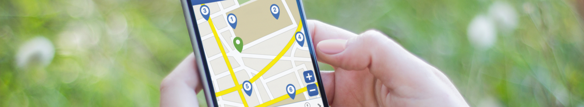 A person is holding a cell phone with a map on it.