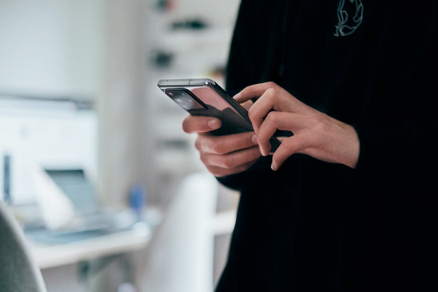 A person is holding a cell phone in their hands.