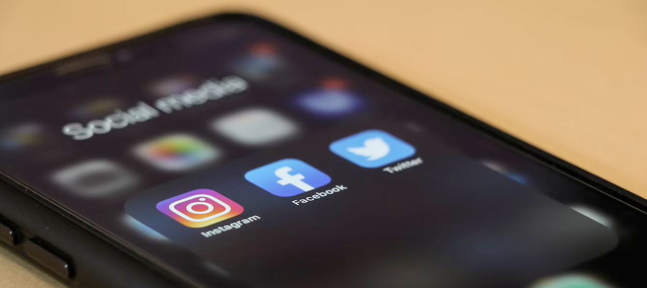 A close up of a cell phone with social media icons on the screen.