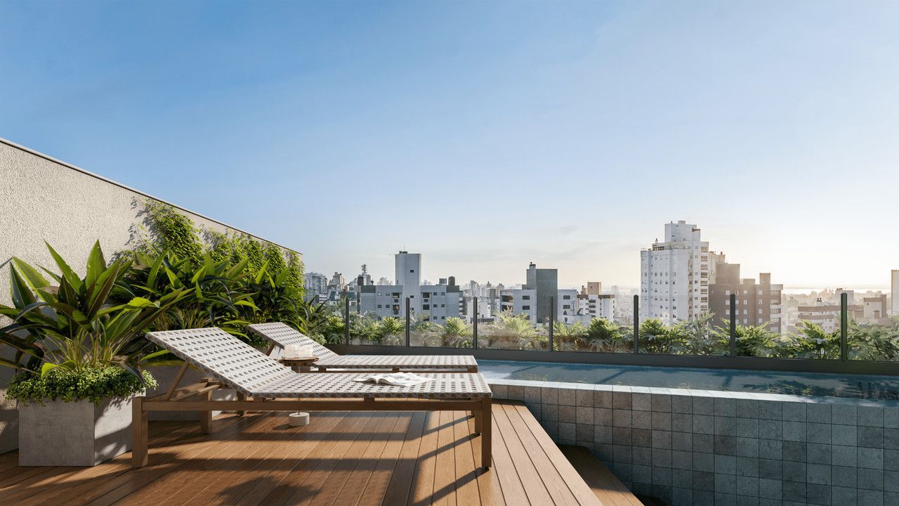 Há uma piscina na cobertura de um prédio com vista para a cidade.