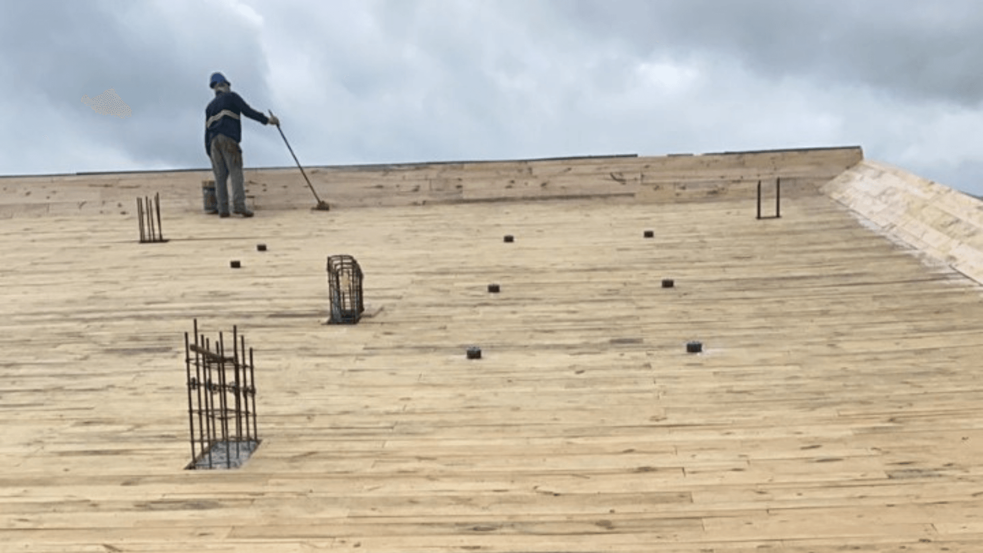 Um homem está em cima de um telhado de madeira.