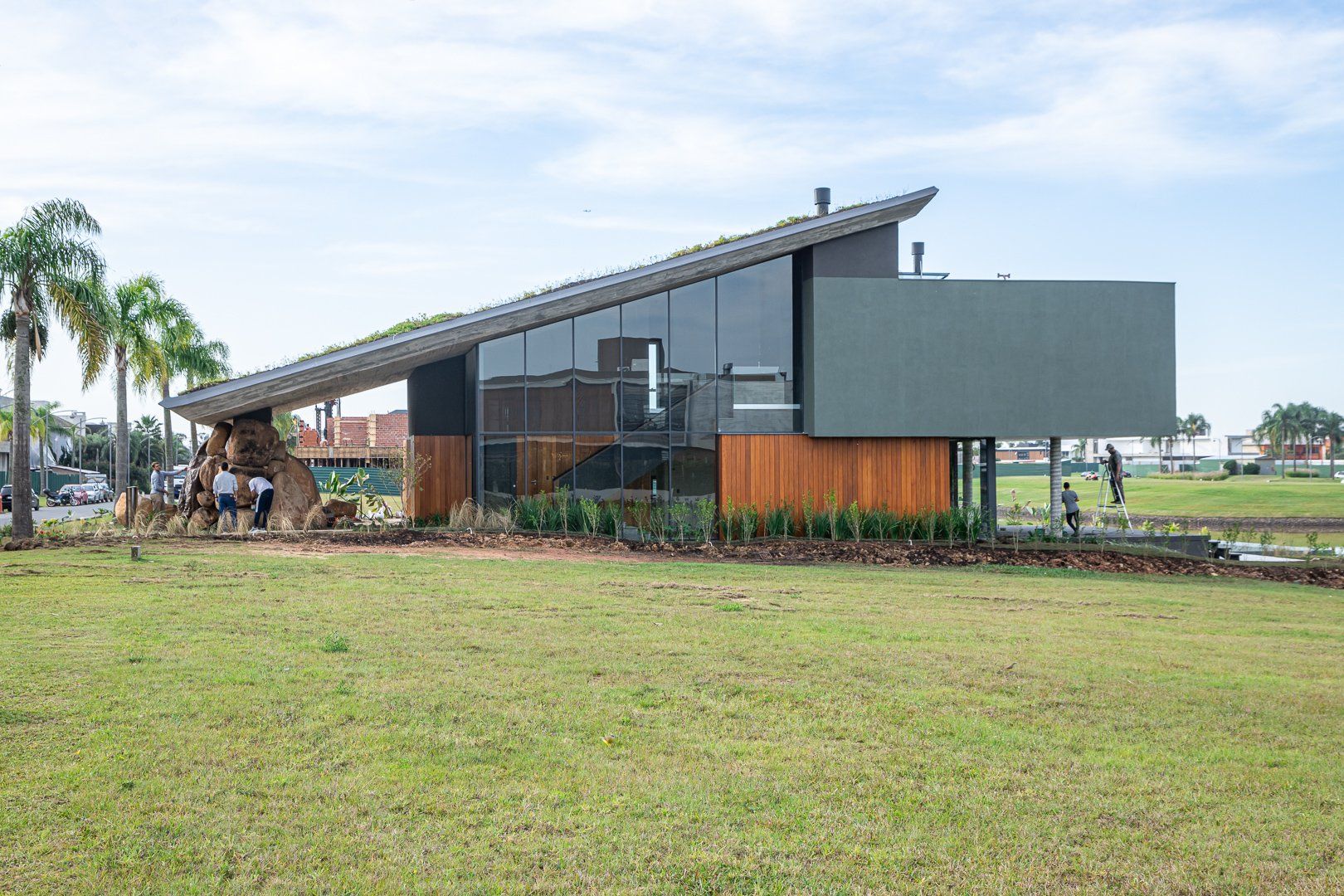 Uma casa moderna está situada no topo de um campo verdejante.