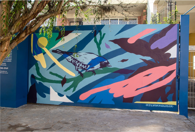 Uma parede azul com a pintura de um pássaro