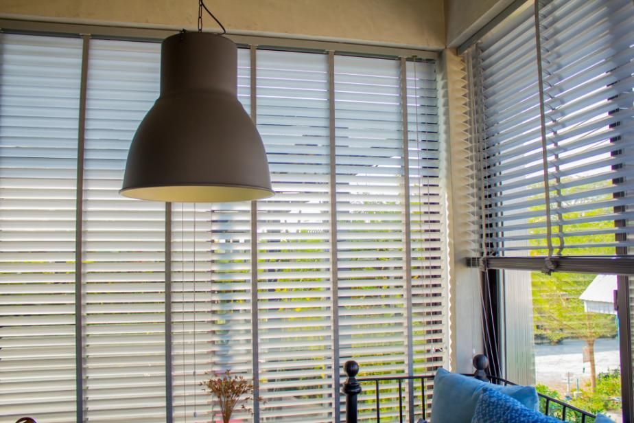 A Living Room With Blinds On The Windows And A Lamp Hanging From The Ceiling — Outdoor Blinds In Berkeley Vale, NSW