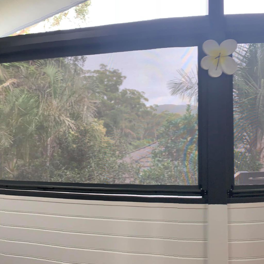 A Window With A Flower On It And A View Of Trees — Outdoor Blinds In Berkeley Vale, NSW