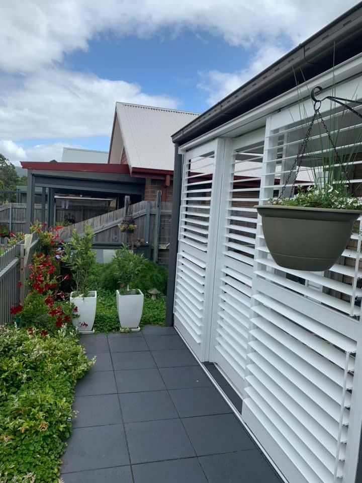 A House With A Patio With Shutters And Hanging Plants — Outdoor Blinds In Berkeley Vale, NSW