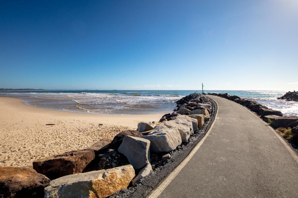 A Road Leading To A Beach With Rocks On The Side Of It — Outdoor Blinds In Cooranbong, NSW