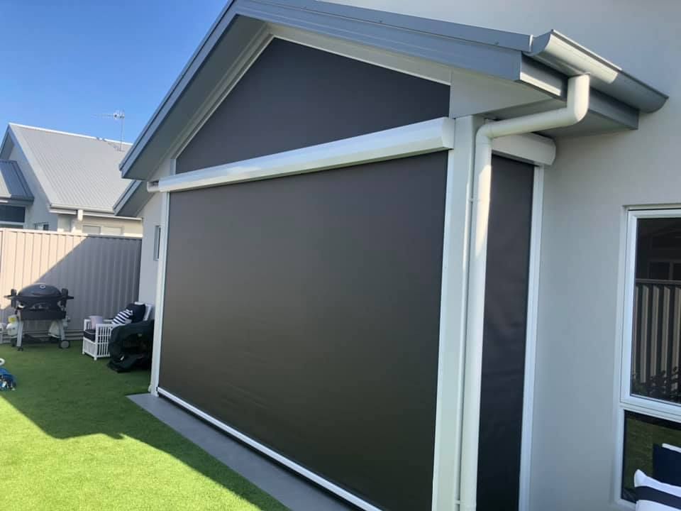 A House With A Large Screen On The Side Of It — Outdoor Blinds In Berkeley Vale, NSW