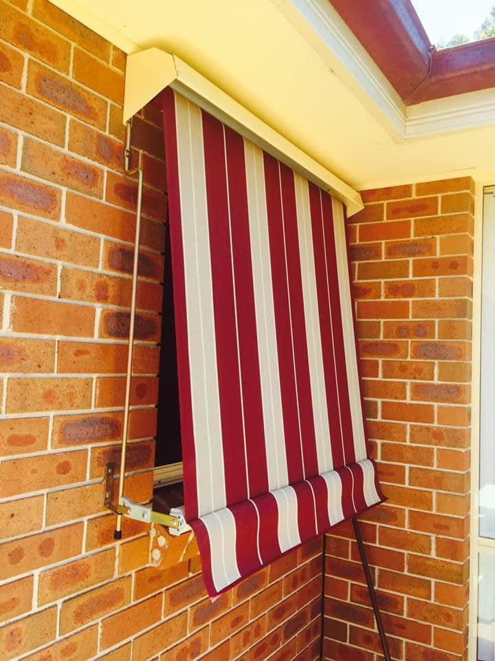 A Window With A Red And White Striped Awning On It — Outdoor Blinds In Berkeley Vale, NSW