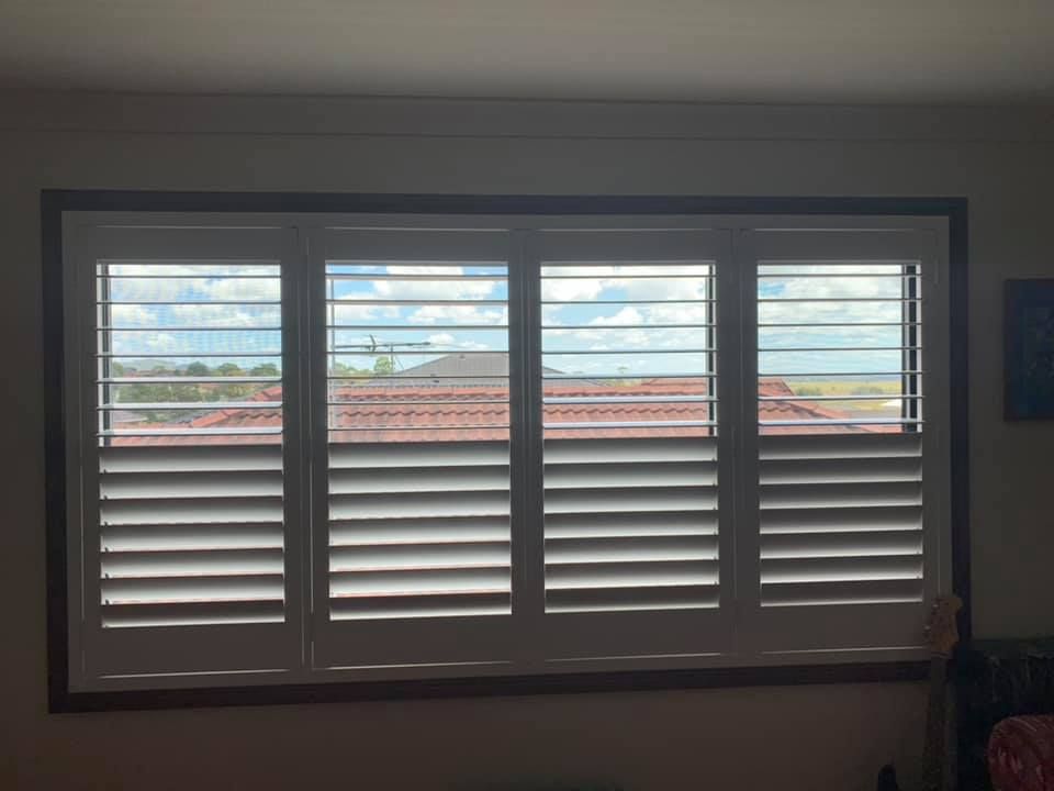 A Large Window With Venetian Blinds In A Living Room — Outdoor Blinds In Berkeley Vale, NSW
