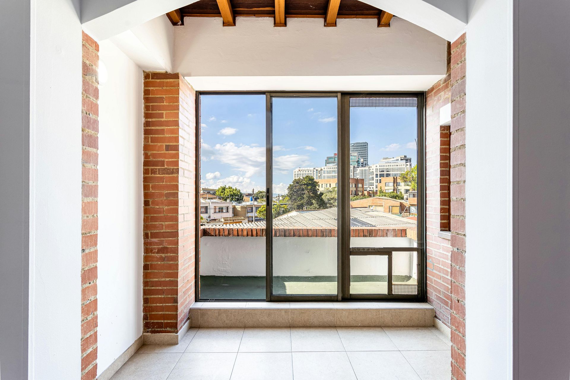 Glass doors with silver frames and handles, brick wall to the right.