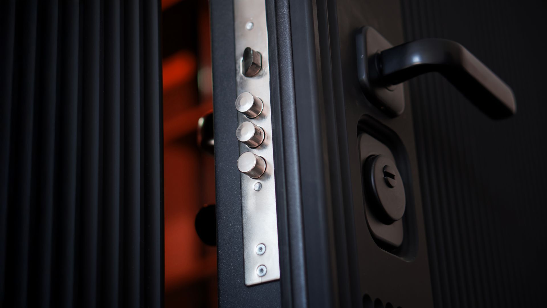 Black security door with multiple locking bolts. Black handle and keyhole visible.