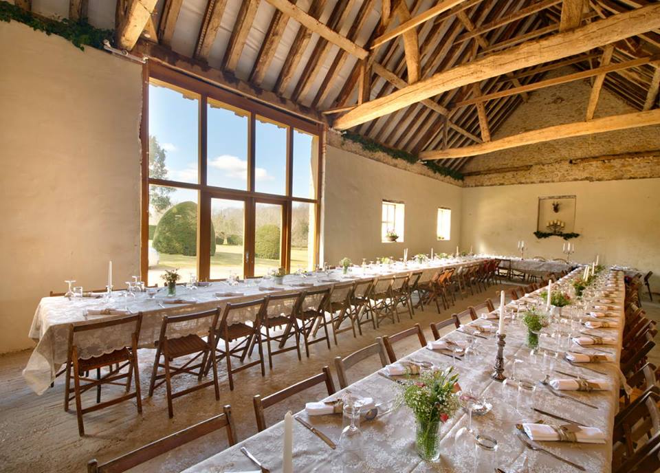 The Wedding Barn at New Barn Farm, with its ancient, characterful oak beams, decorated and set for a wedding breakfast.