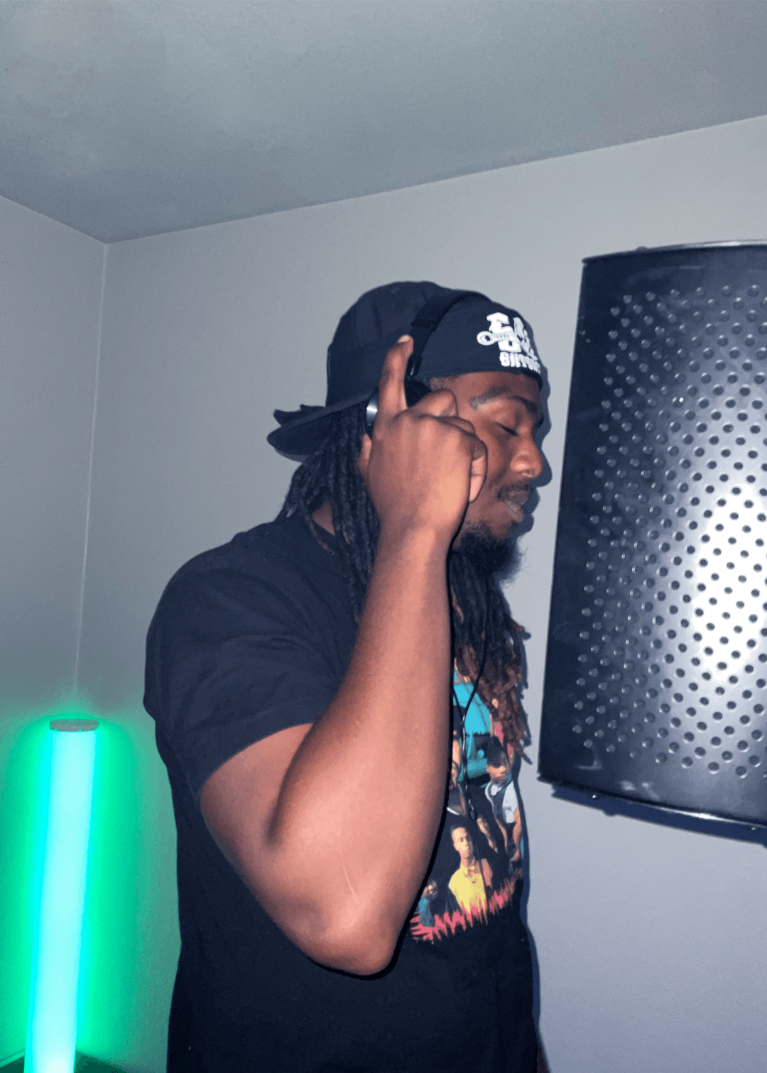 A man with dreadlocks is wearing a la hat