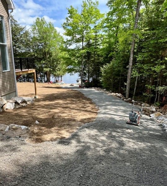 A dirt road leading to a house in the woods