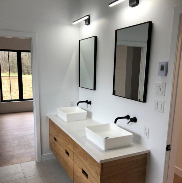 A bathroom with two sinks and two mirrors