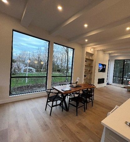A living room with a table and chairs and lots of windows