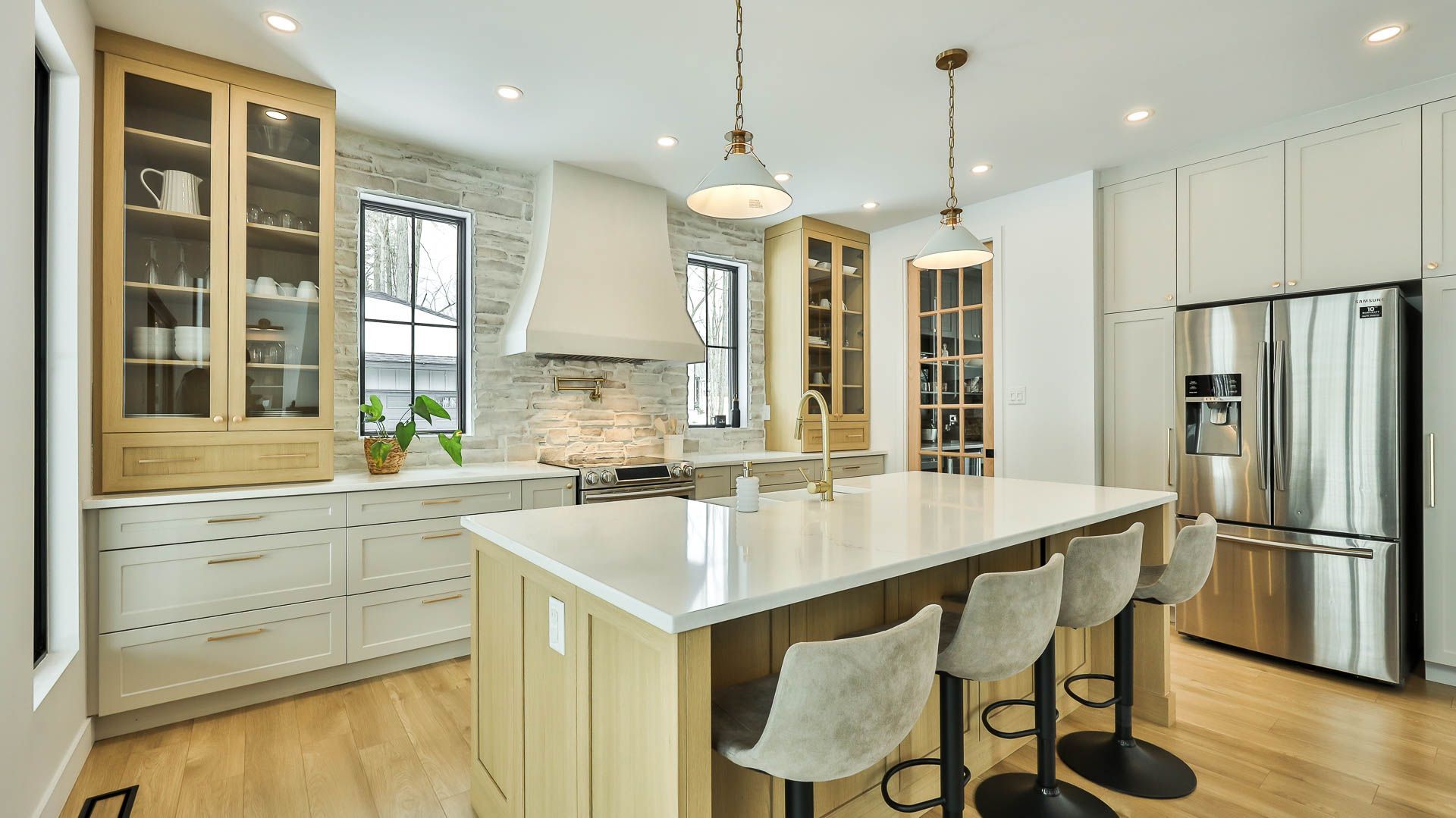 A kitchen with white cabinets , stainless steel appliances , and a large island.