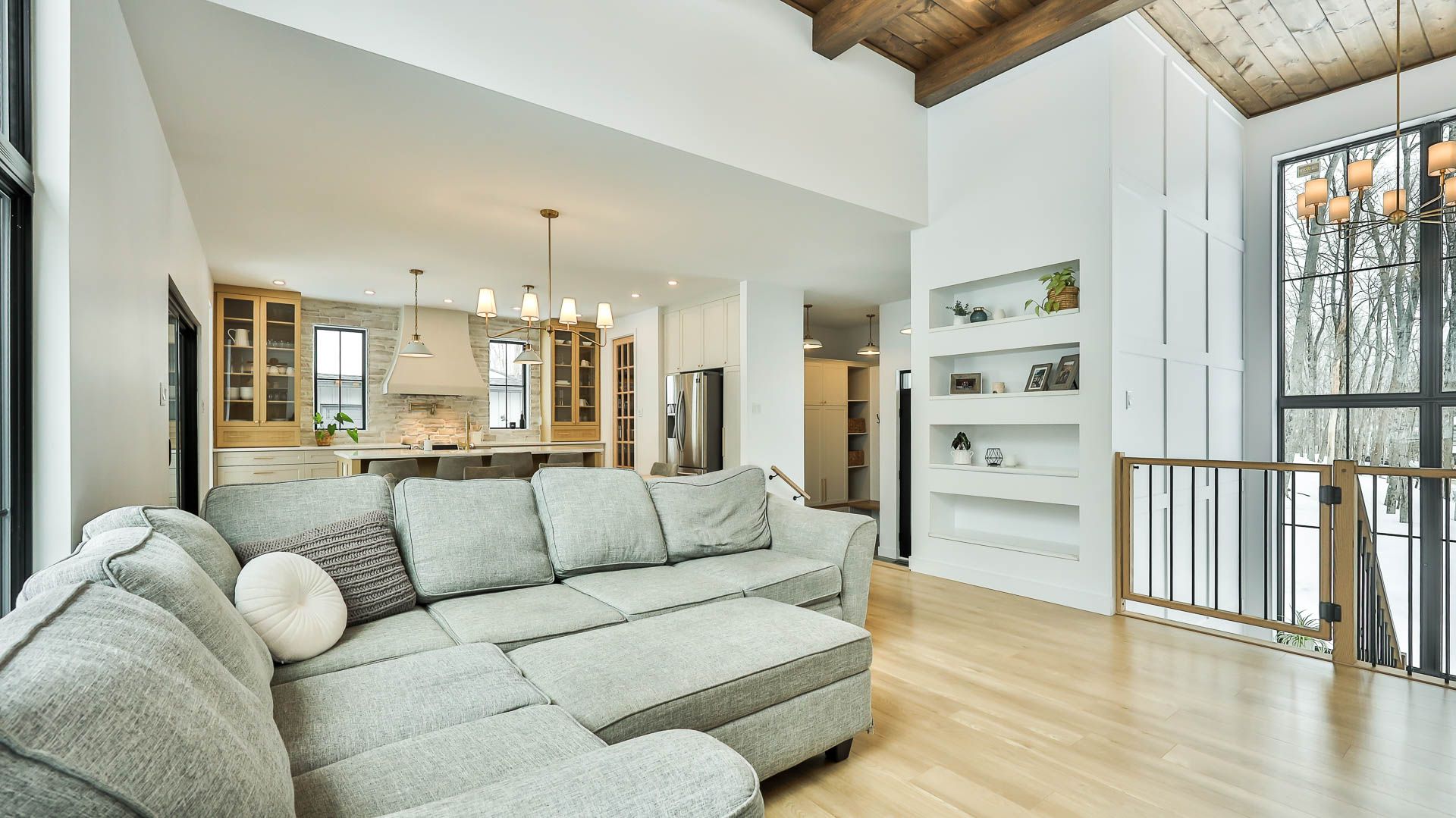 A living room with a couch and a staircase leading to the kitchen.