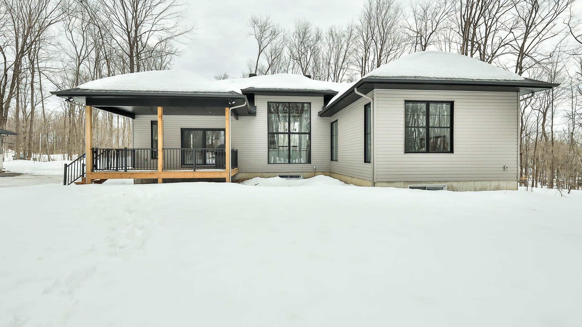 A house is sitting in the middle of a snow covered field.