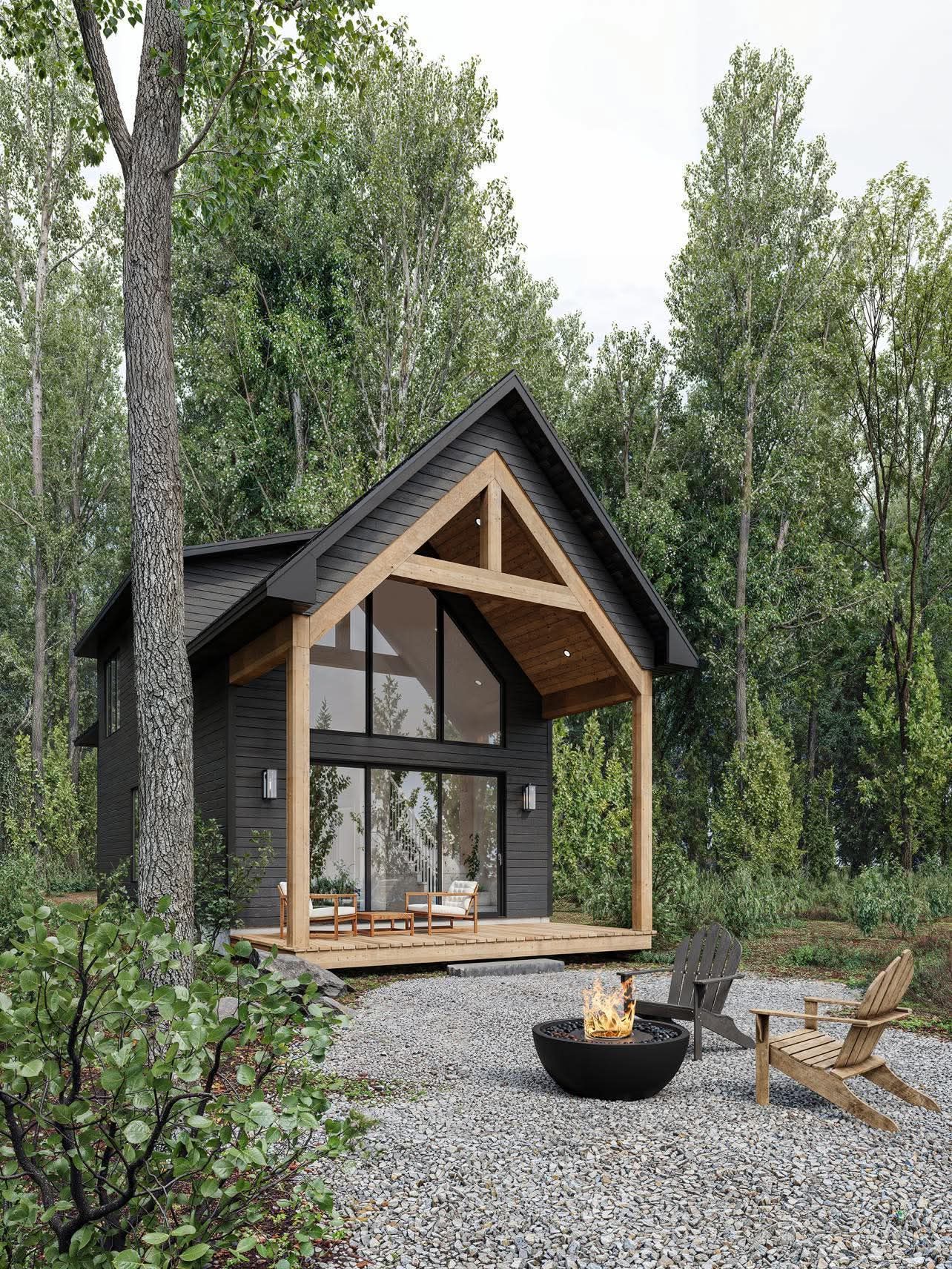 A small house in the middle of a forest with a fire pit in front of it.