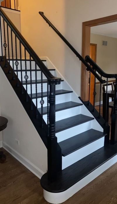 Staircase with black railings and white steps, featuring a stairlift on the right side.