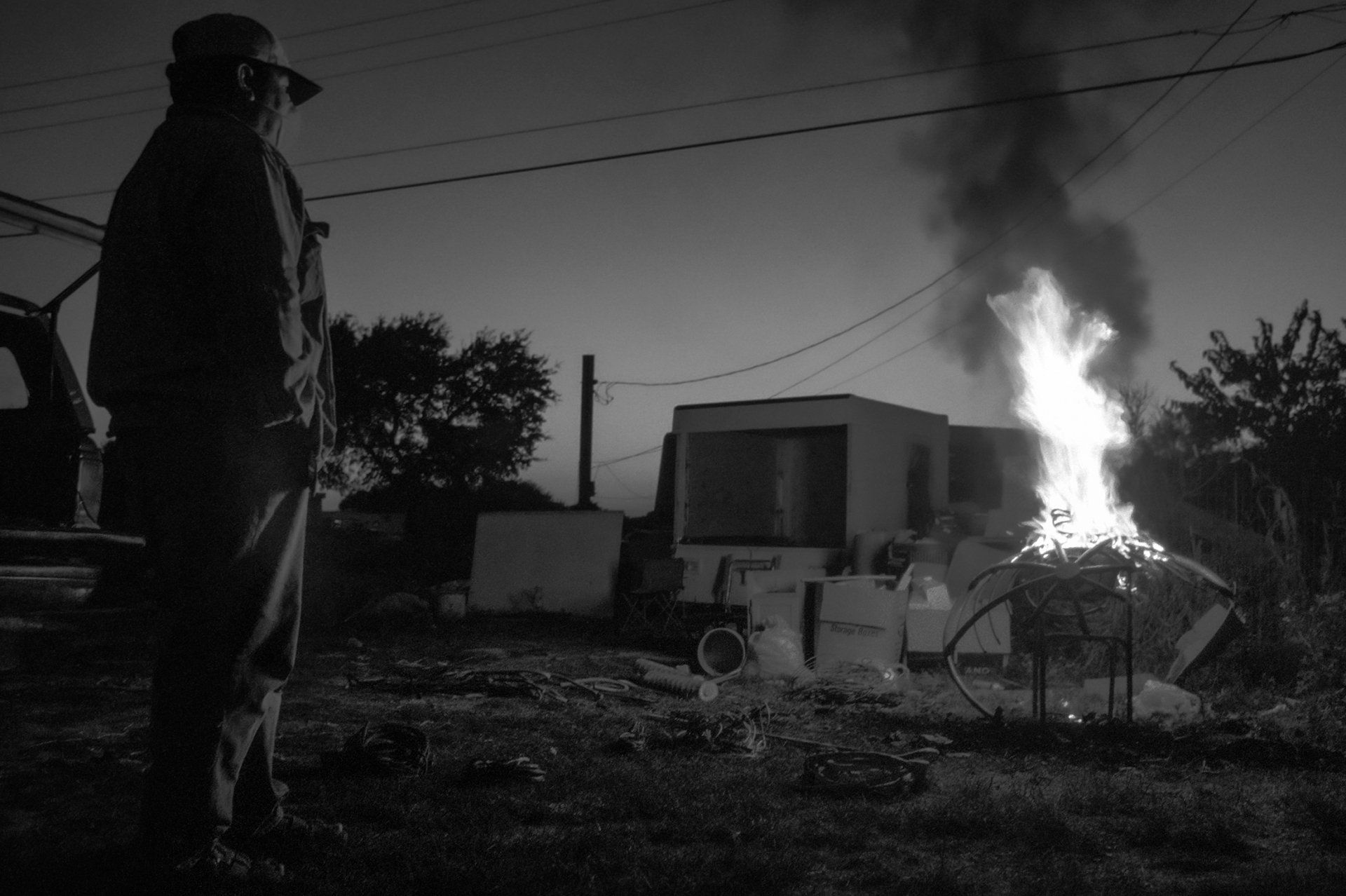Ismael uses their furniture to start a fire to melt the plastic coating off of scavenged copper wire.