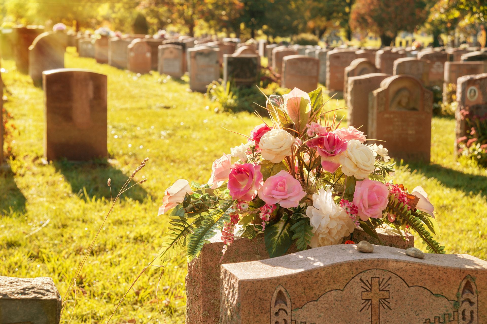 a grave in a cemetery with flowers on it