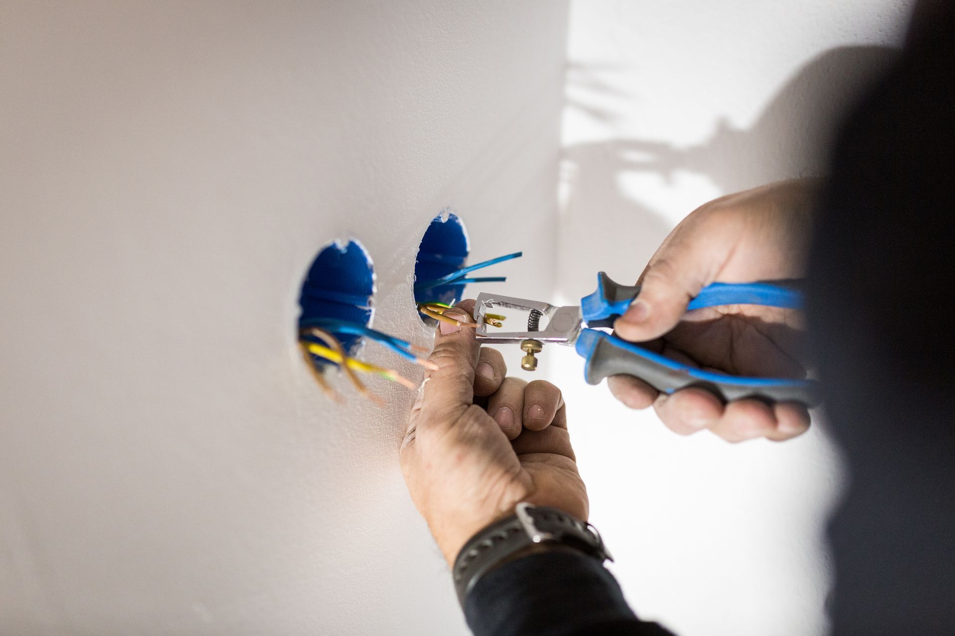 A person is cutting a wire with a pair of pliers.