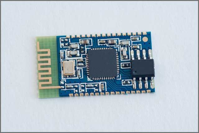 Blue circuit board with a gold antenna, various chips, and connectors.