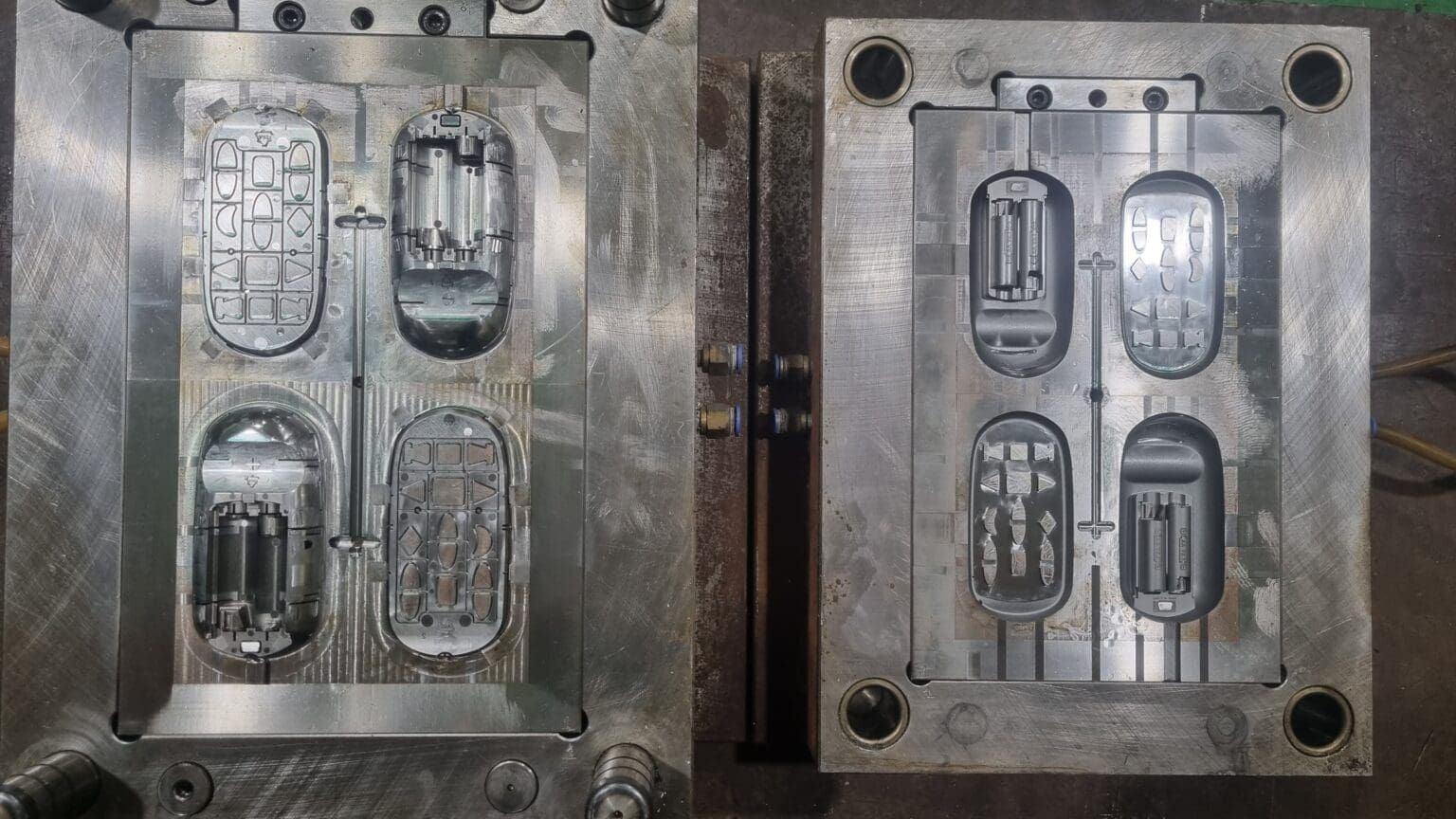 Two metal molds, each with four cavities for forming plastic components.