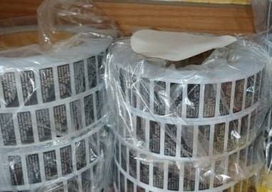 Rolls of labels, wrapped in plastic. Each label is rectangular with text.